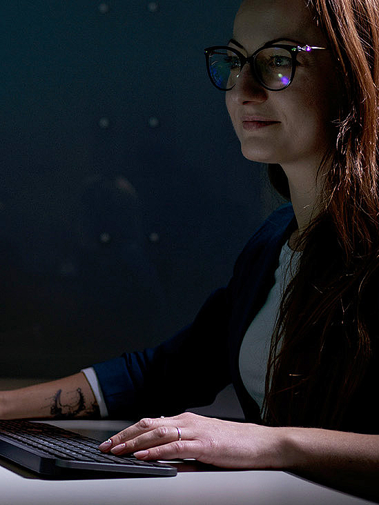 Woman with a smartTOUCH Flex, standard keyboard and multiple screens