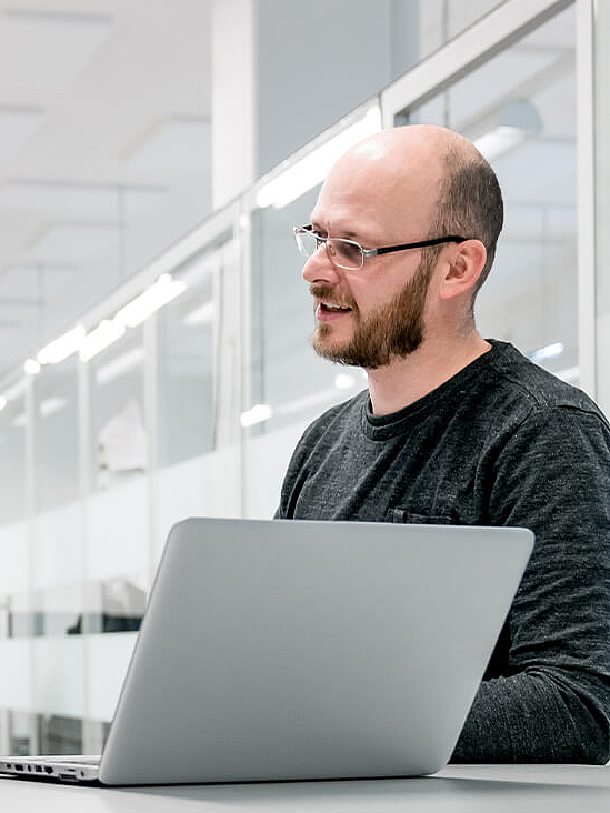 Two men at a laptop having a conversation