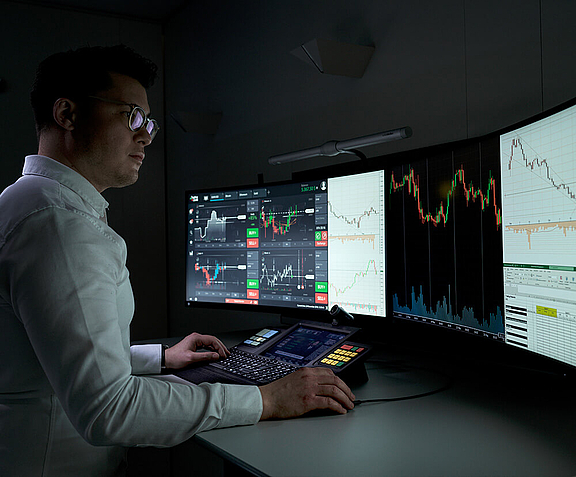 Man standing at trading workplace with several screens